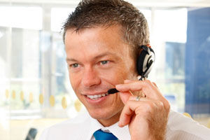 male call center agent holding headset speaker