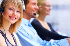 female call center agent looking at camera sitting next to two other agents