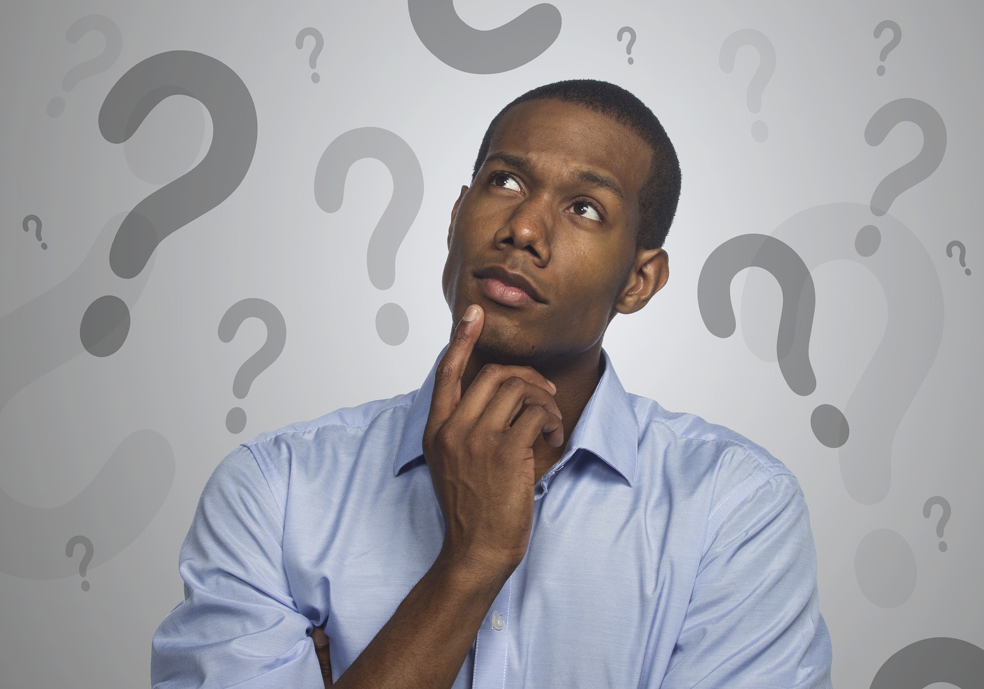 thinking man surrounded by question marks