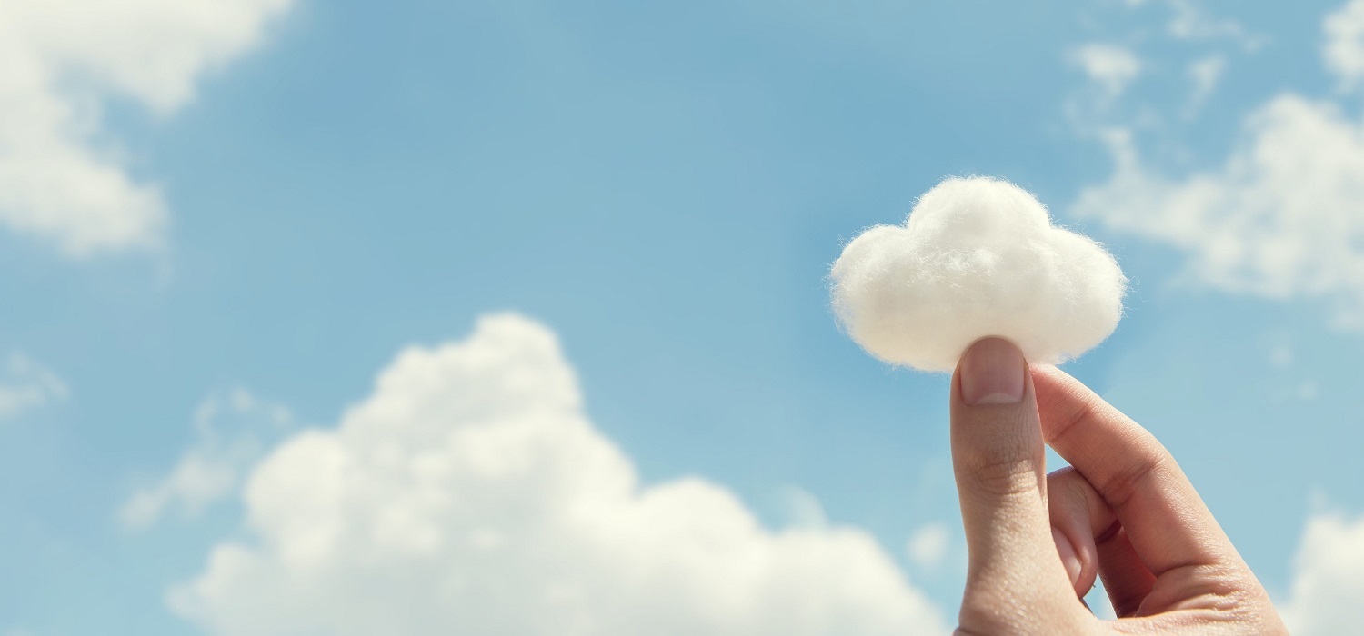 a hand holding a small cloud on the backdrop of a sky