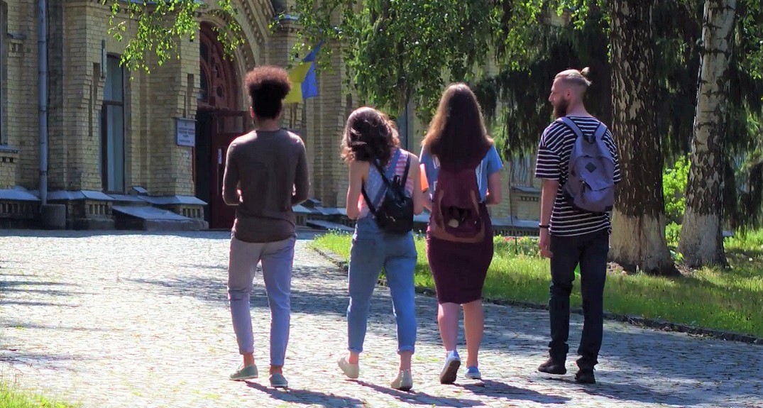group of students walking down path on college campus
