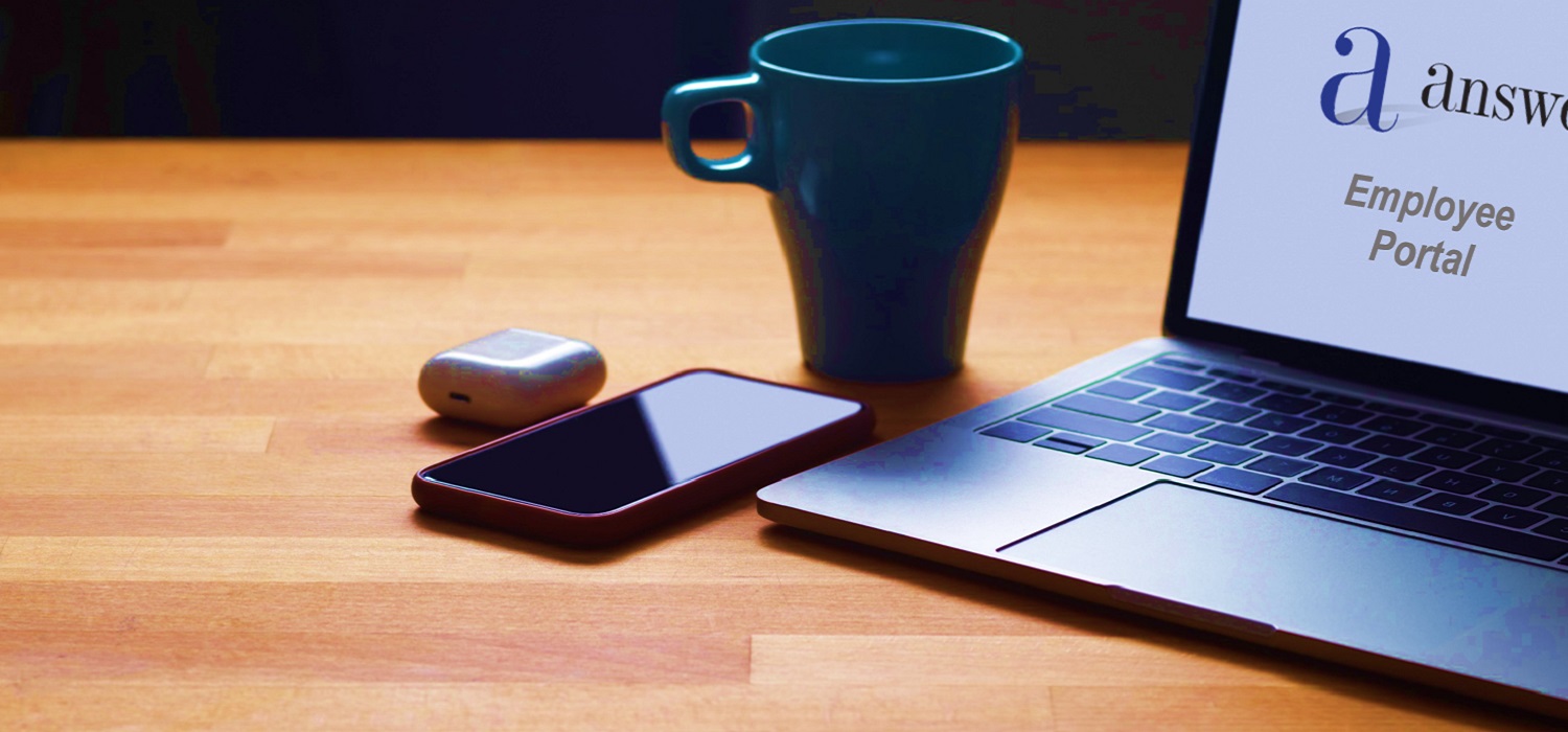 a desk with coffee cup, mobile phone and laptop screen with AnswerNet logo