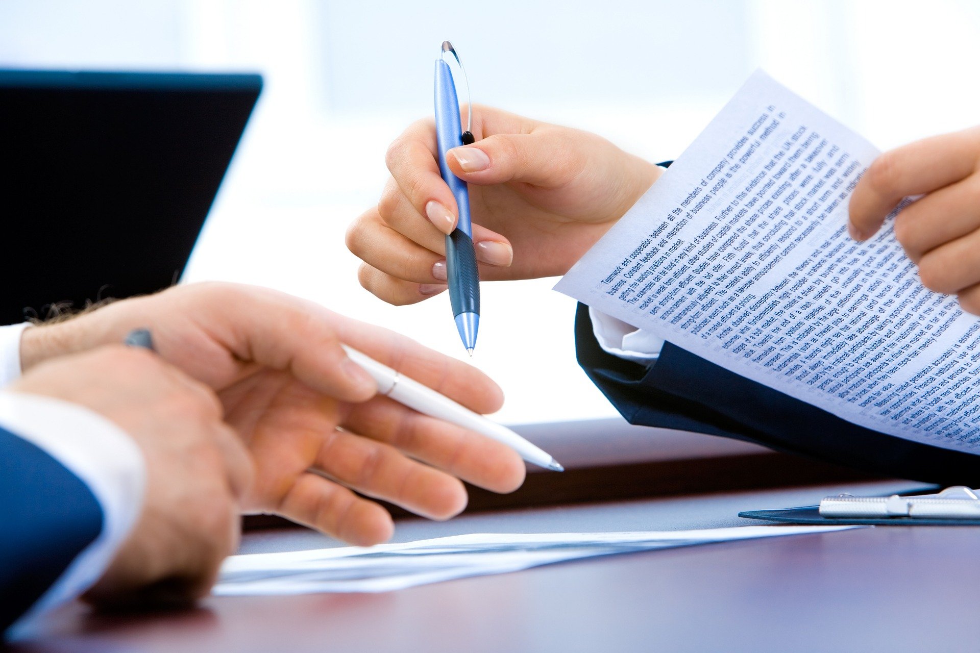 two individuals signing contracts