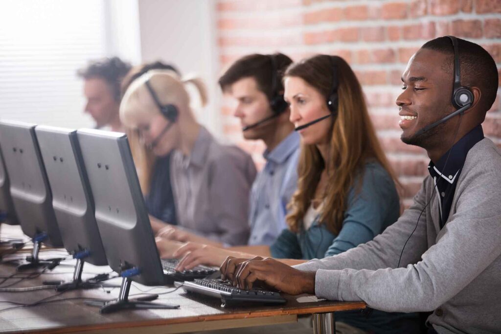 a group of happy call center agents lined down a desk